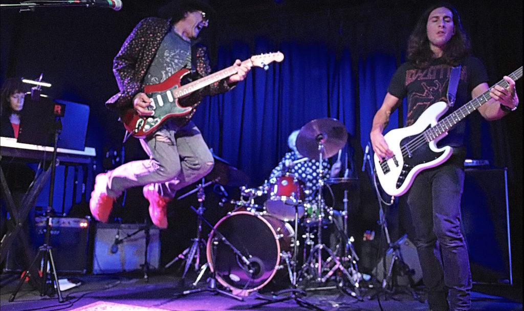 Band leader NO leaps through the air during a performance at Molly Malone's - Photo © 2018 Alyson Camus