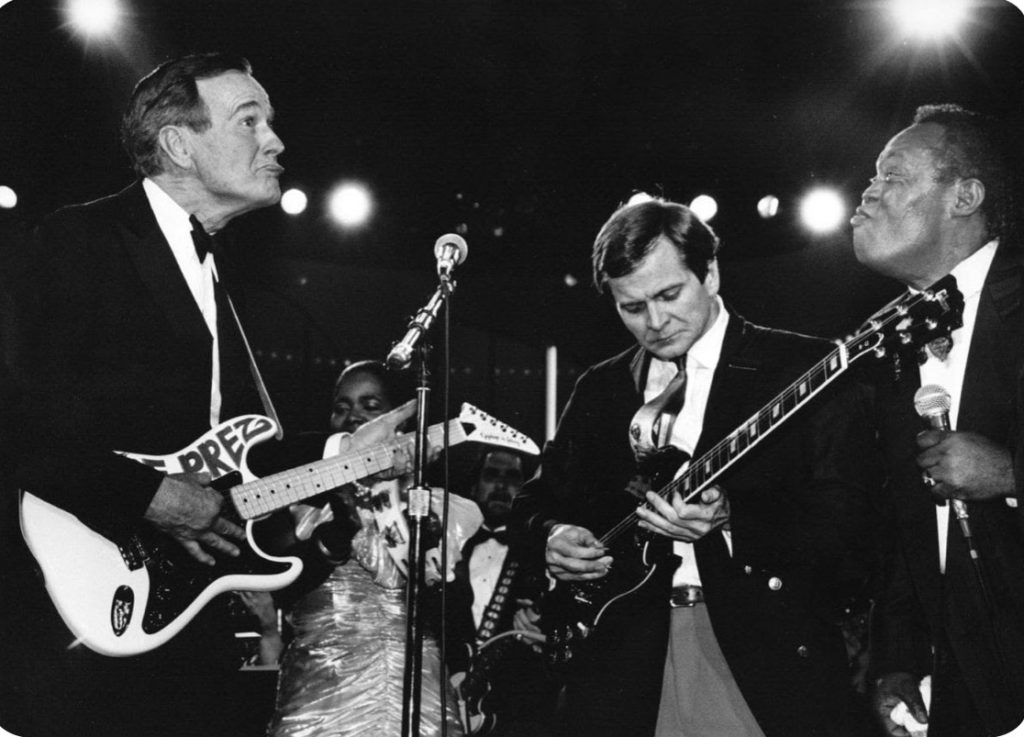 After receiving "The Prez" guitar -- a present -- from Sam Moore of the former Sam and Dave soul duo, President Bush, left, plays the instrument with Republican National Committee Chairman Lee Atwater on Jan. 21, 1989. (Rick Lipski/The Washington Post)
